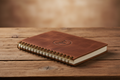 Closed brown leather RanchHand Daily Planner notebook on a rustic wooden table